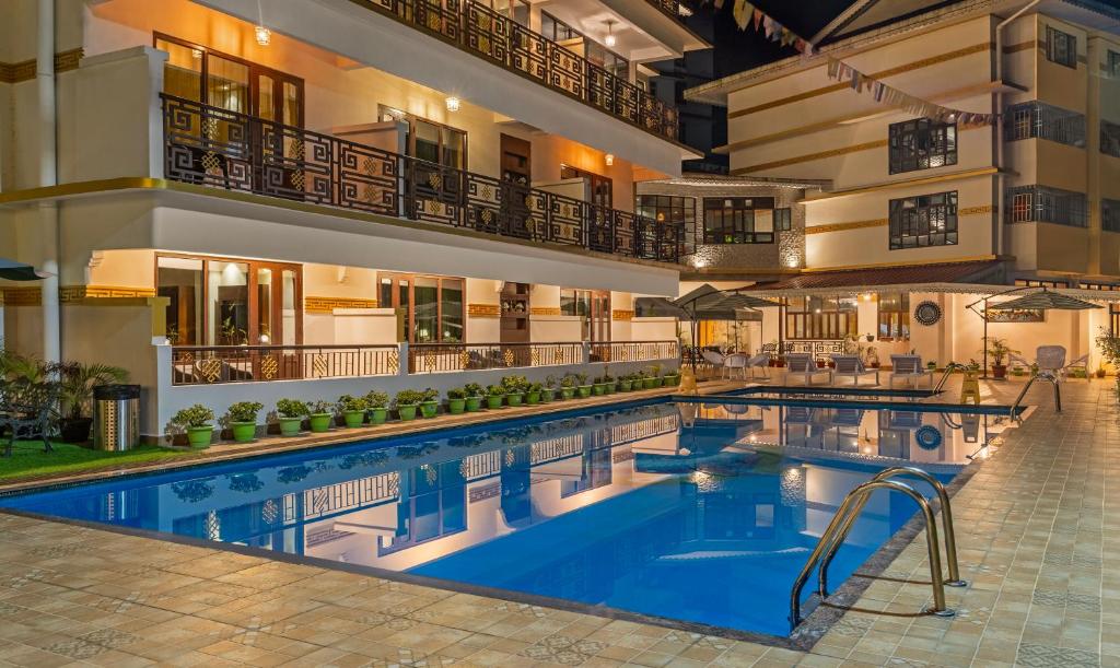una piscina de hotel con un hotel en el fondo en Treebo Tryst Tempo Heritage Spa & Resort en Gangtok