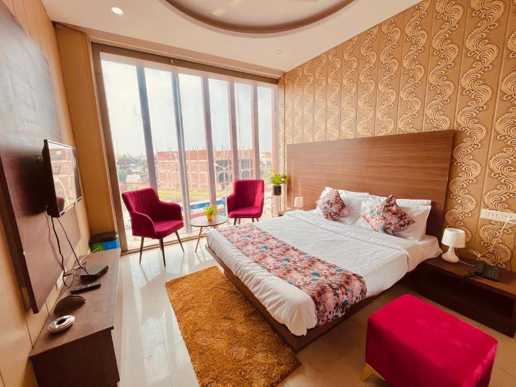 a bedroom with a large bed and a large window at Hotel Pearl Grand, Zirakpur - Top Rated & Most Awarded Property in Tricity in Chandīgarh