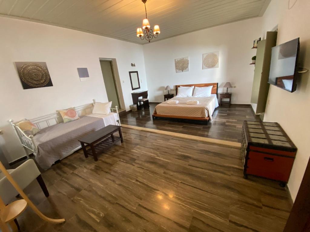 Großes Zimmer mit 2 Betten und einem Tisch in der Unterkunft Castle Rizaraki in Kokkala