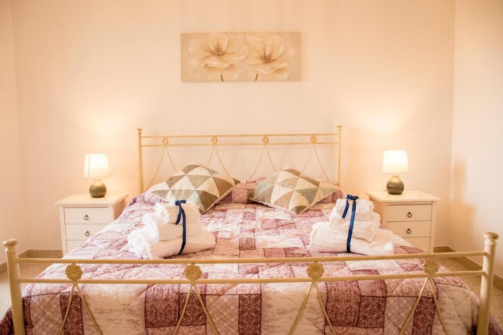 een slaapkamer met een bed met 2 nachtkastjes en 2 lampen bij Locorotondo Home Holidays in Locorotondo