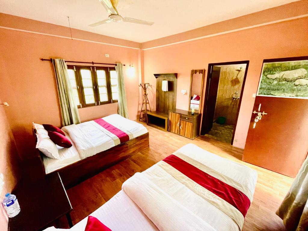 sypialnia z 2 łóżkami w pokoju w obiekcie Hotel Tree Tops- A Serene Friendly Hotel in Sauraha w mieście Chitwan