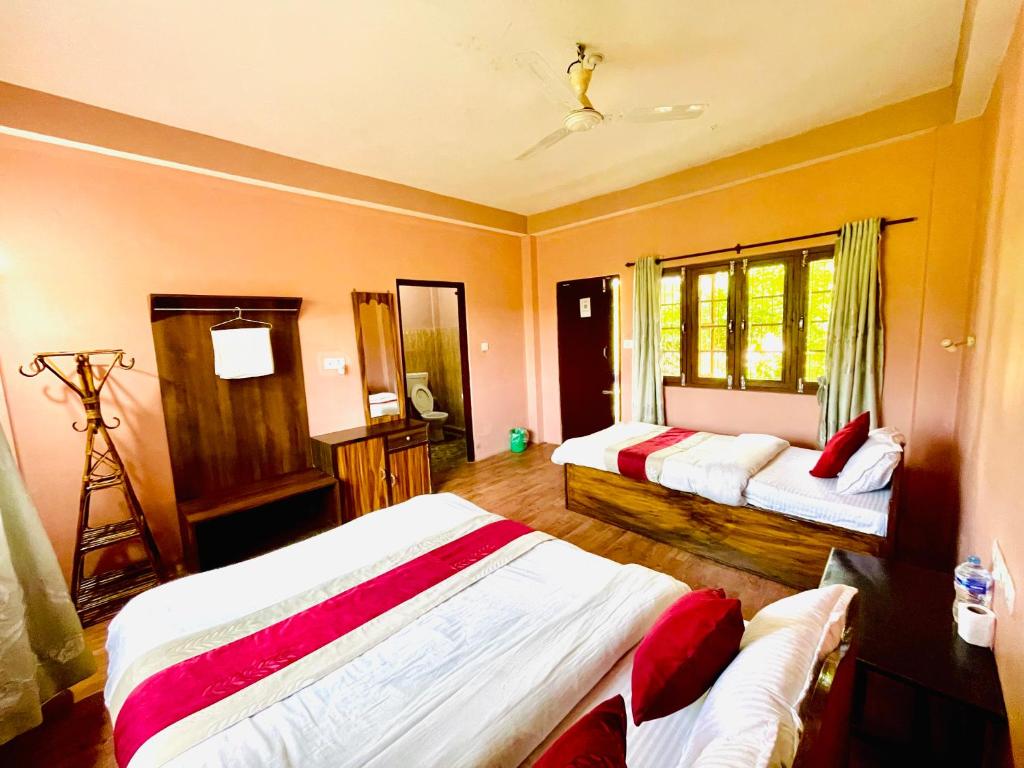a bedroom with two beds and a camera at Hotel Tree Tops- A Serene Friendly Hotel in Sauraha in Chitwan