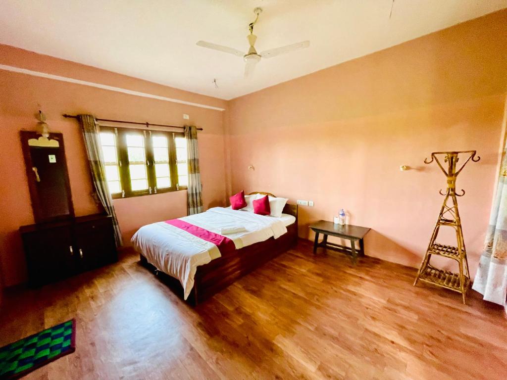 a bedroom with a bed and a wooden floor at Hotel Tree Tops- A Serene Friendly Hotel in Sauraha in Chitwan