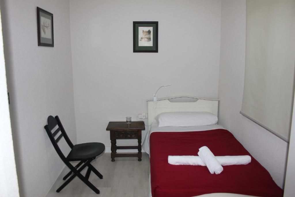 Habitación pequeña con cama y silla en The Flats, en Ávila