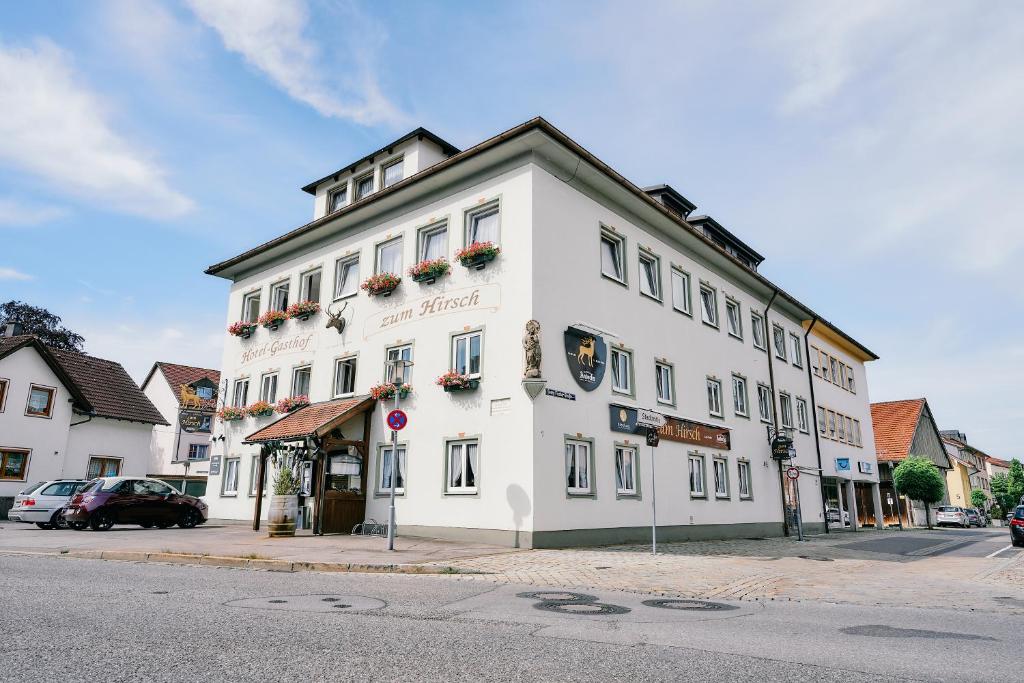 a white building on the corner of a street at Blochums Gasthof Hirsch in Marktoberdorf