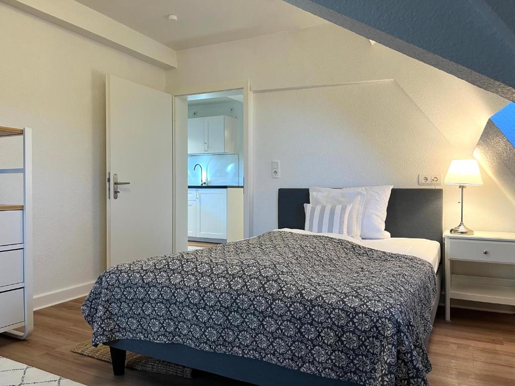 een kleine slaapkamer met een bed en een deur naar een keuken bij Kleines, feines Apartment in historischer Burg in Schlitz in Schlitz