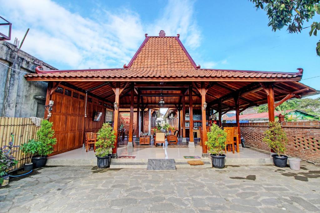 een groot houten paviljoen met een tafel en stoelen bij OYO 92606 Djoglo Boto Homestay Syariah in Yogyakarta