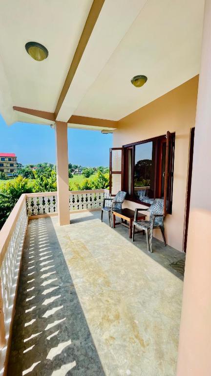 a patio with a table and chairs on a balcony at Hotel Tree Tops- A Serene Friendly Hotel in Sauraha in Chitwan