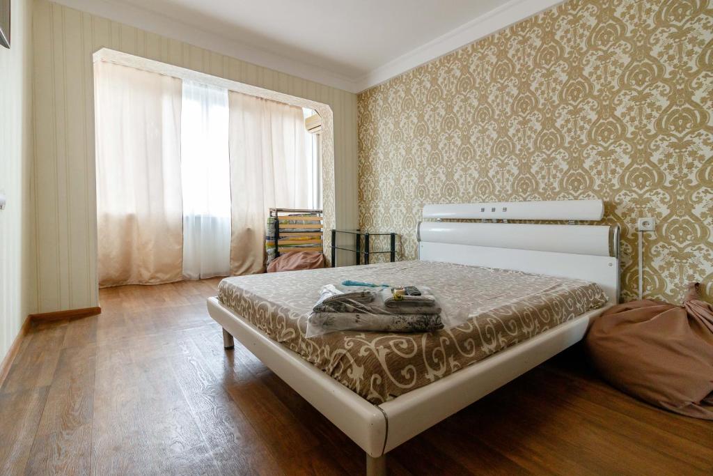 Un dormitorio con una cama en una habitación con ventana. en Kvartirkoff na Obolonskiy prospekt 31, en Kiev