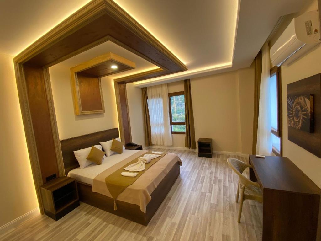 ein Schlafzimmer mit einem Bett und einem Schreibtisch in einem Zimmer in der Unterkunft Perla Blanca Hotel in Trabzon