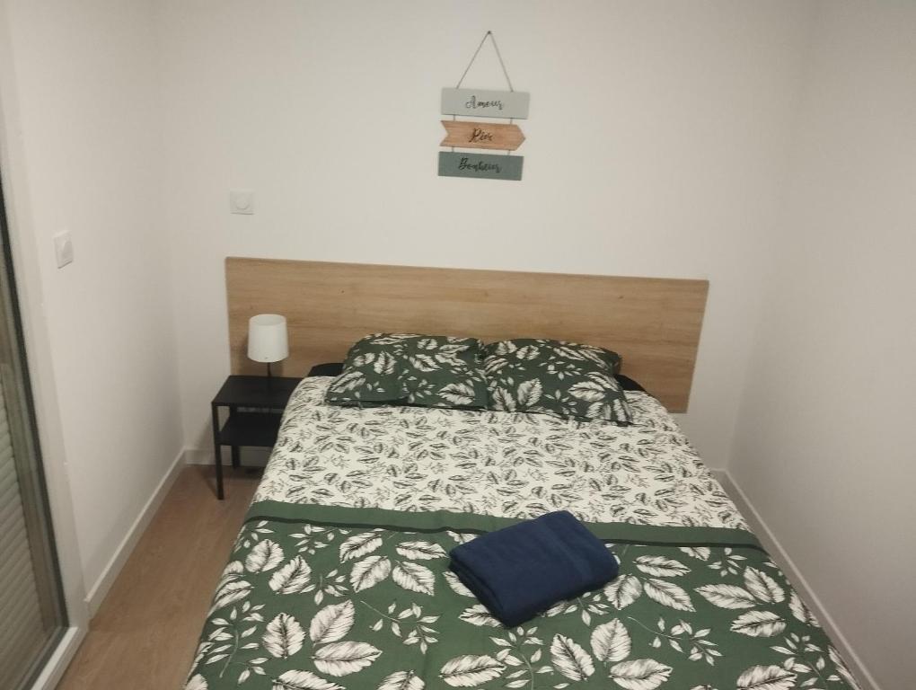 a bedroom with a bed with a green and white comforter at ALBICASA appart hotel in Albi