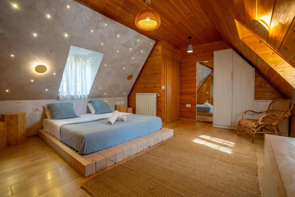 una camera da letto con un grande letto in mansarda di Hotel Restaurant Alpet Theth a Theth