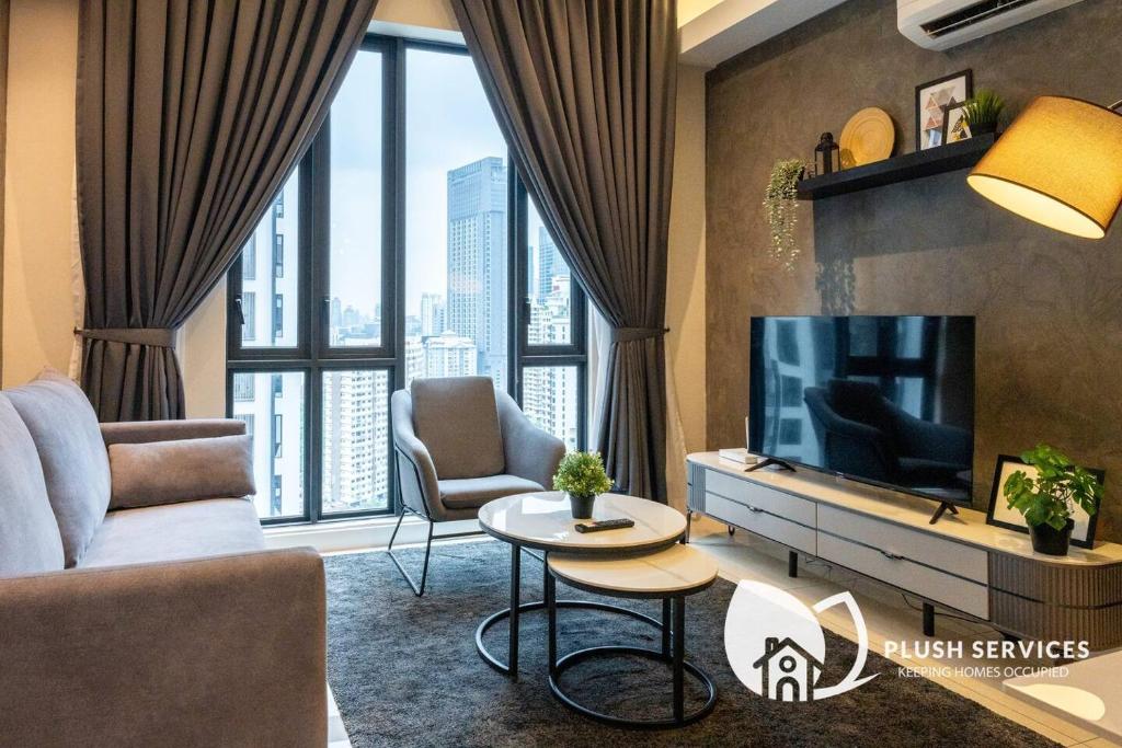 a living room with a tv and a large window at Sentral Suites by Plush in Kuala Lumpur