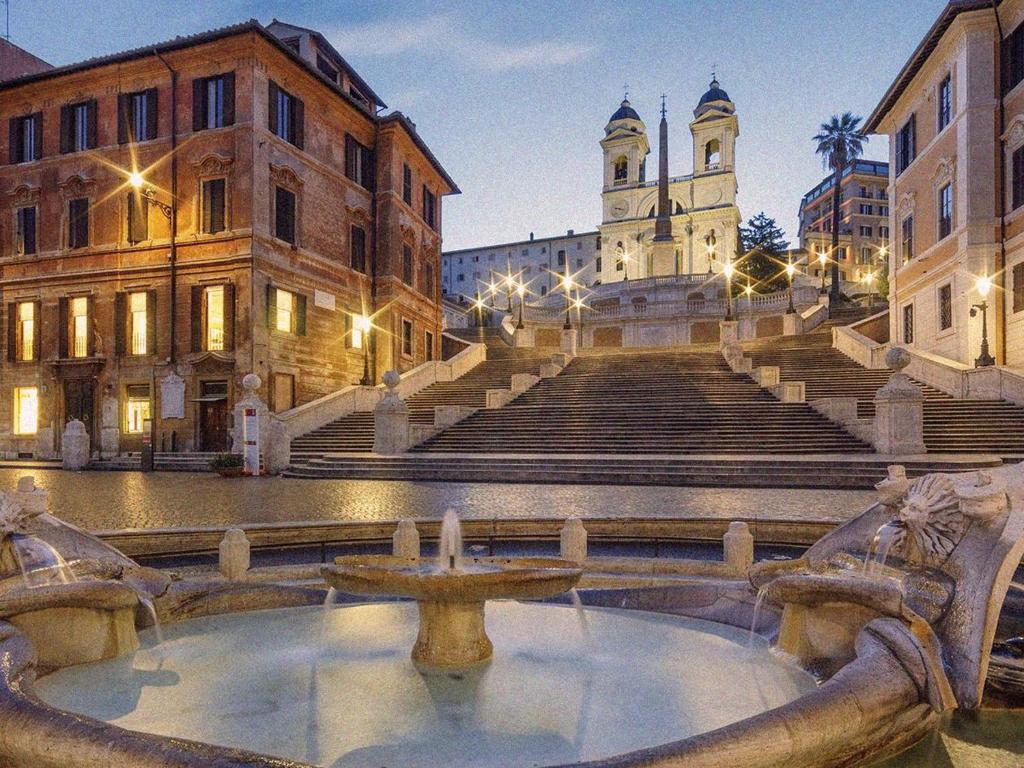 ein Gebäude mit einem Brunnen mitten auf einer Straße in der Unterkunft Parisii Bocca di Leone 88 in Rom