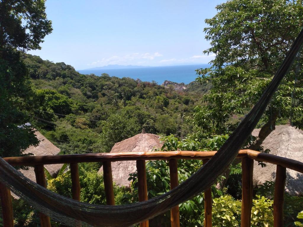 een hangmat op een terras met de oceaan op de achtergrond bij Tree House Bungalows Koh Tao in Ko Tao