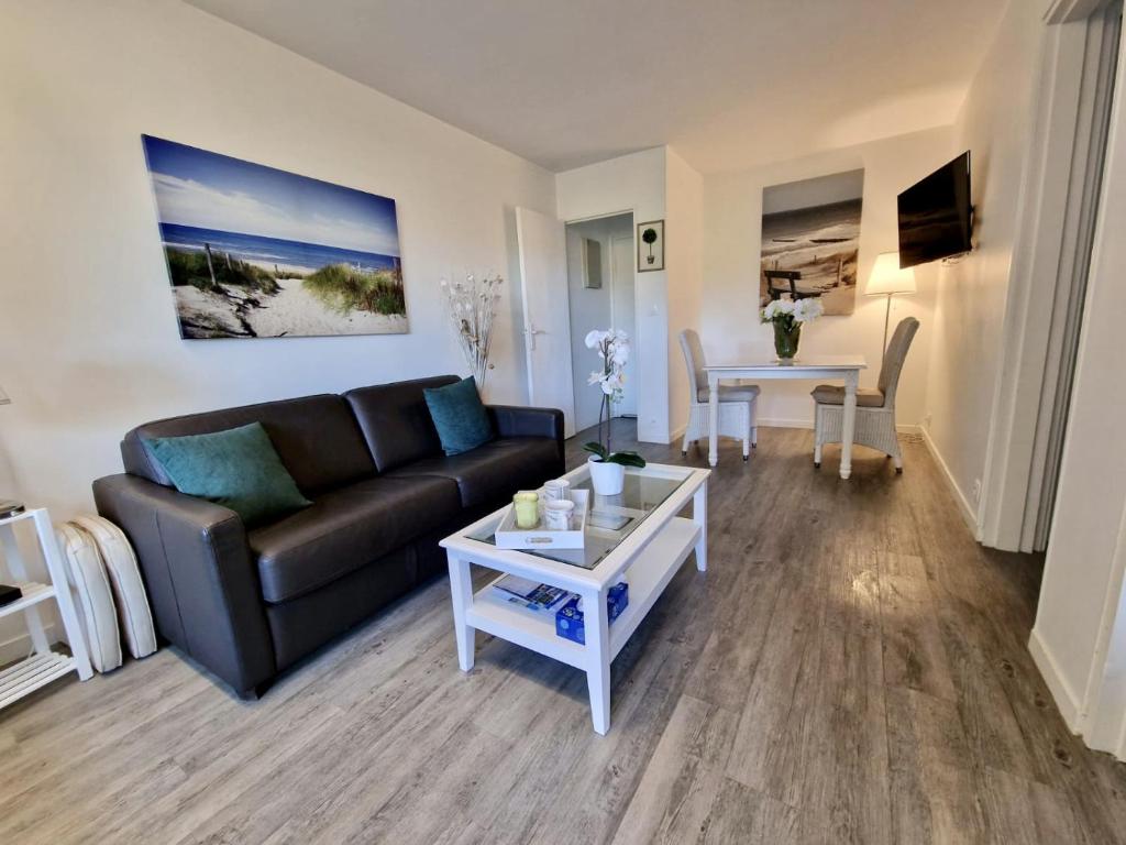 un salon avec un canapé et une table dans l'établissement Charmant 2 pièces à deux pas de la mer, à Cabourg