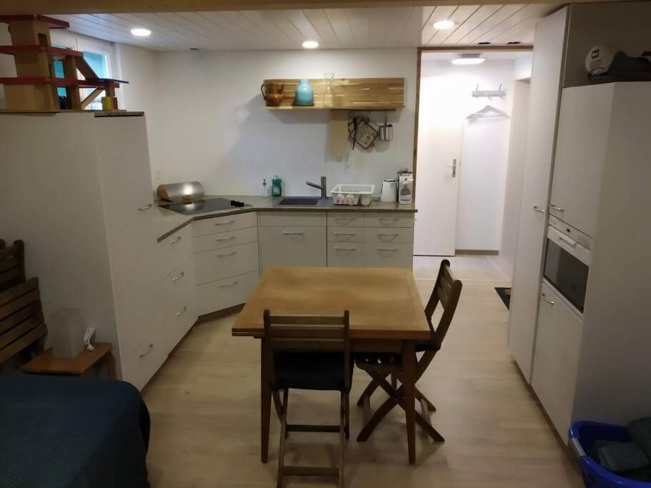 eine Küche mit einem Tisch und Stühlen im Zimmer in der Unterkunft Bijou 1 Hübsche 1 Zimmer Wohnung in Herisau
