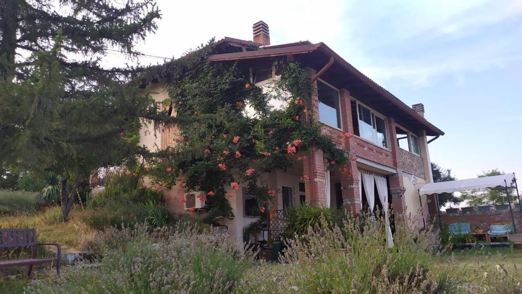 an old house with flowers on the side of it at Casa Fernanda in Montecalvo Versiggia