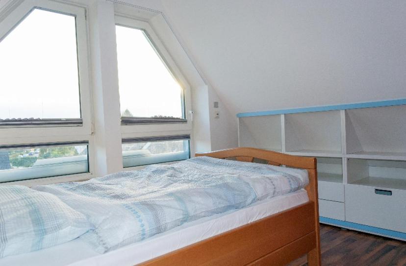 a bedroom with a bed and two windows at Unter den Sternen in Bottrop
