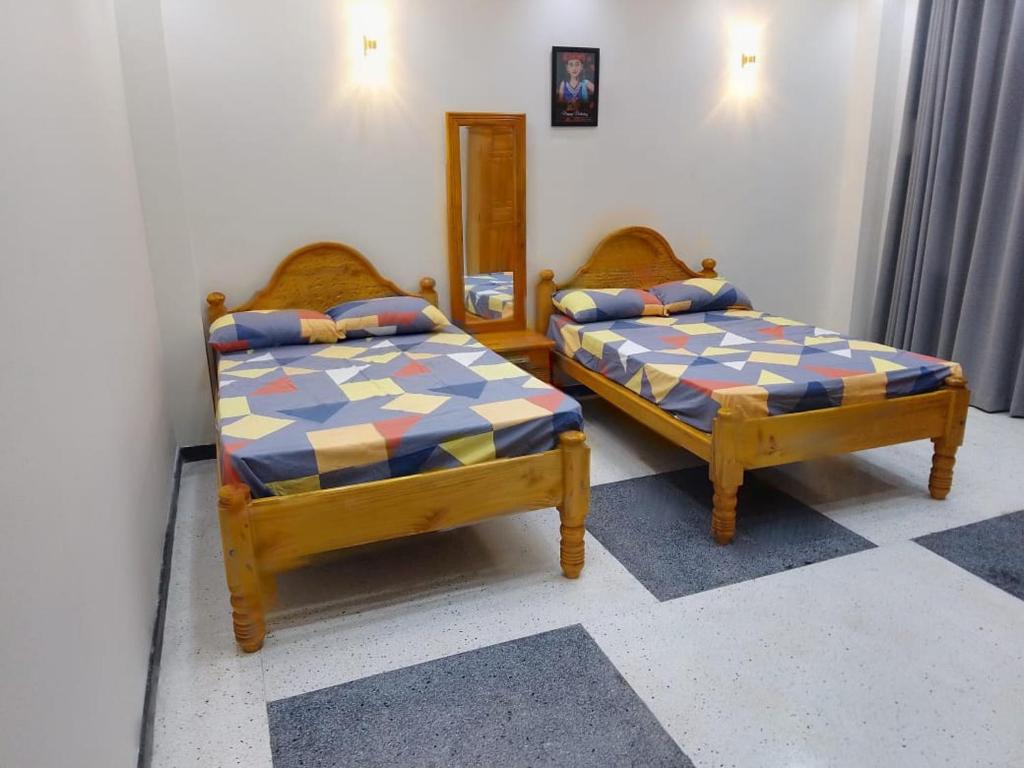 two beds sitting next to each other in a room at Sabari Hotel and Restaurant PVT Ltd in Jaffna