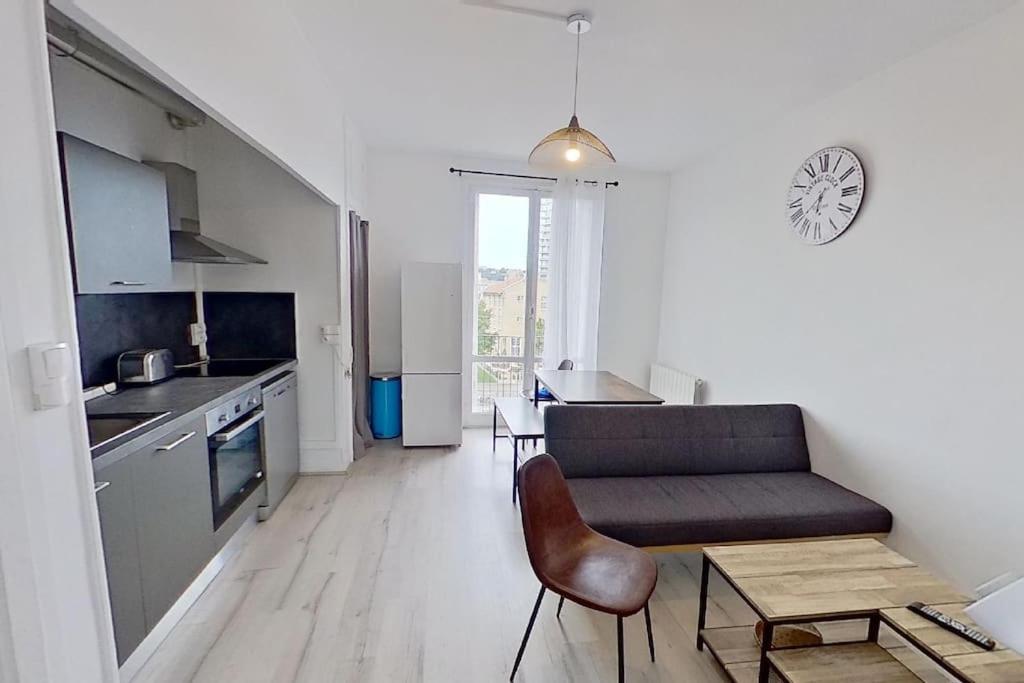 uma cozinha e sala de estar com um sofá e uma mesa em F4 - La Maison de M. Goéland em Le Havre