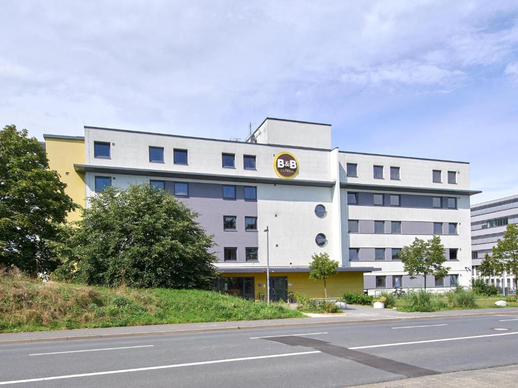 um grande edifício branco com uma placa de ouro em B&B Hotel Darmstadt em Darmstadt