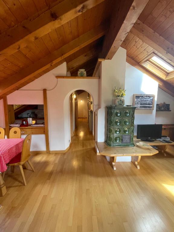 a living room with a wooden floor and a table at Appartamento Monzoni in Pozza di Fassa