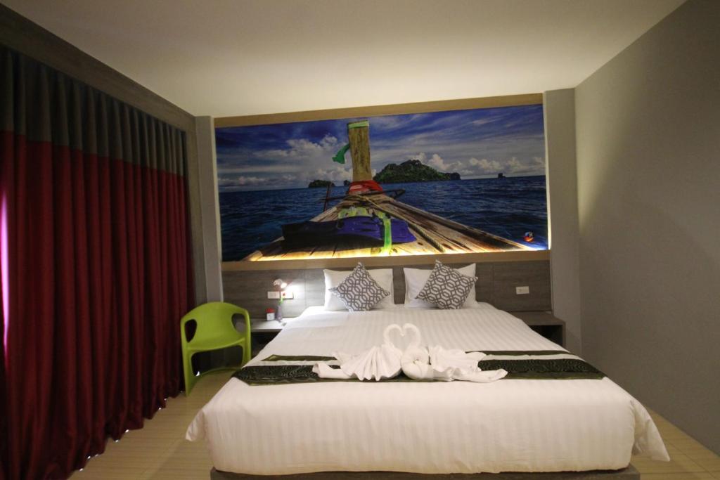 a bedroom with a bed with a large painting on the wall at KRABI CHARM in Ban Khlong Haeng