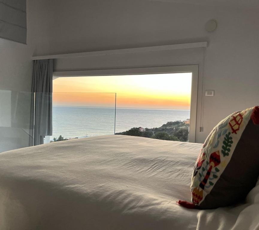 a bedroom with a bed with a view of the ocean at Il Mare di Giù Boutique Guesthouse in Licata