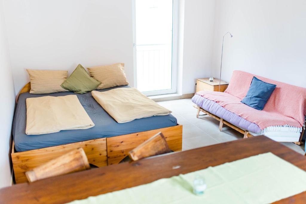 a bedroom with a bed and a couch and a table at Tauglerei Doppelzimmer Bergamotte in Sankt Koloman