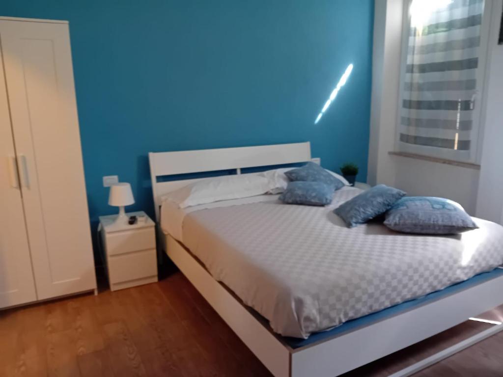 1 dormitorio con 1 cama con pared azul en Via Guido Panciroli il guscio, en Reggio Emilia