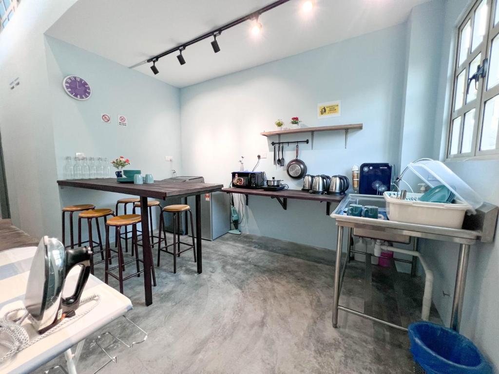 a kitchen with tables and stools in a room at HUKM CoLiving 21 by Manhattan Group in Kuala Lumpur