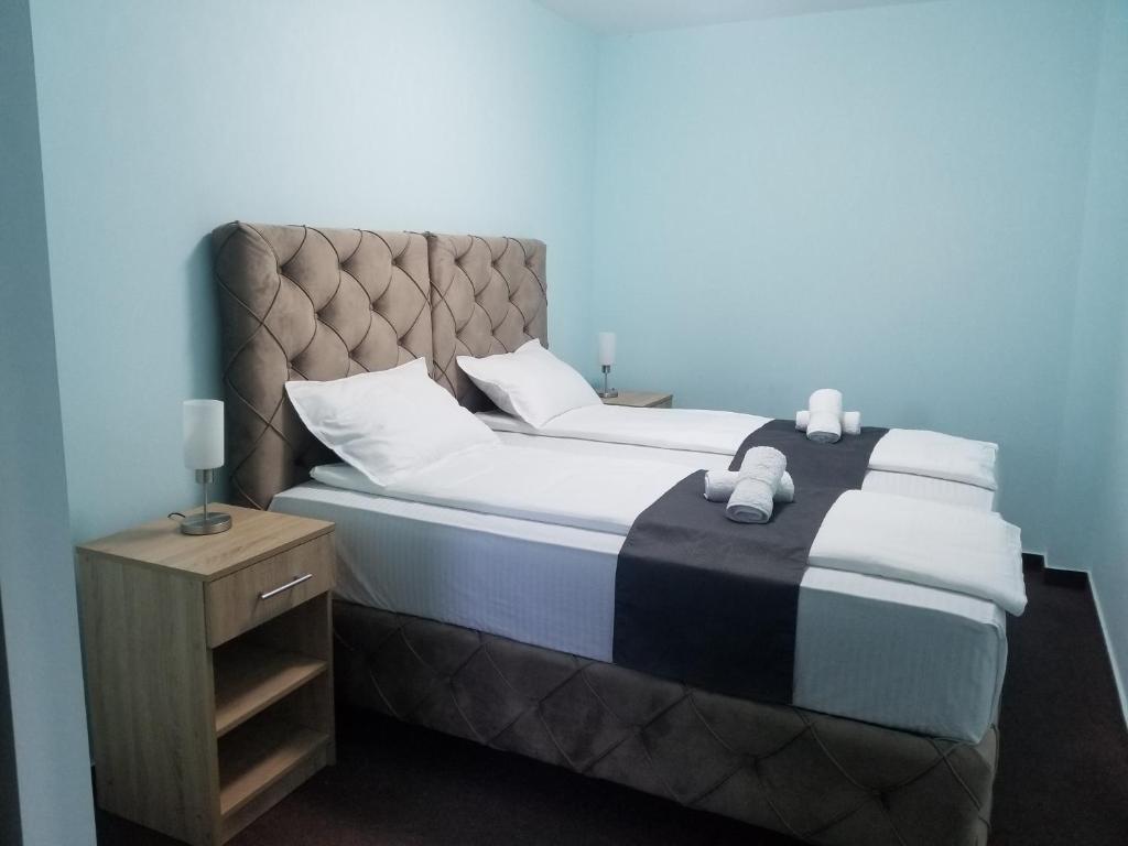 una camera da letto con un grande letto con cuscini bianchi di Villa Dvor SUBOTICA a Subotica