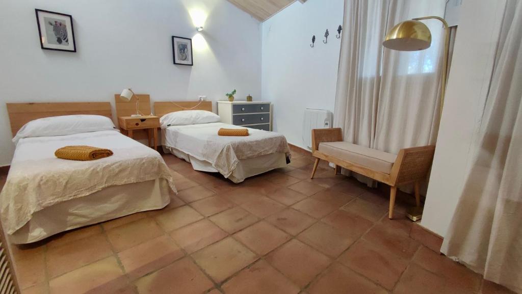 a bedroom with two beds and a desk and a chair at VALDEVAQUEROS HOUSE in Tarifa