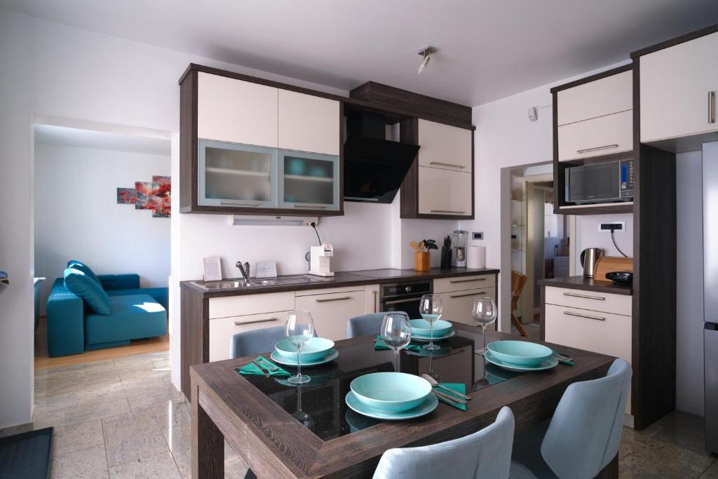 Apartment Kamnik-apartment with a large terrace في كامنيك: مطبخ مع طاولة خشبية مع كراسي وغرفة طعام