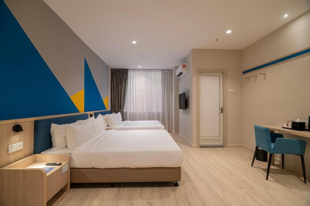 ジョホールバルにあるFives Hotel Meldrumのベッドとデスクが備わるホテルルームです。