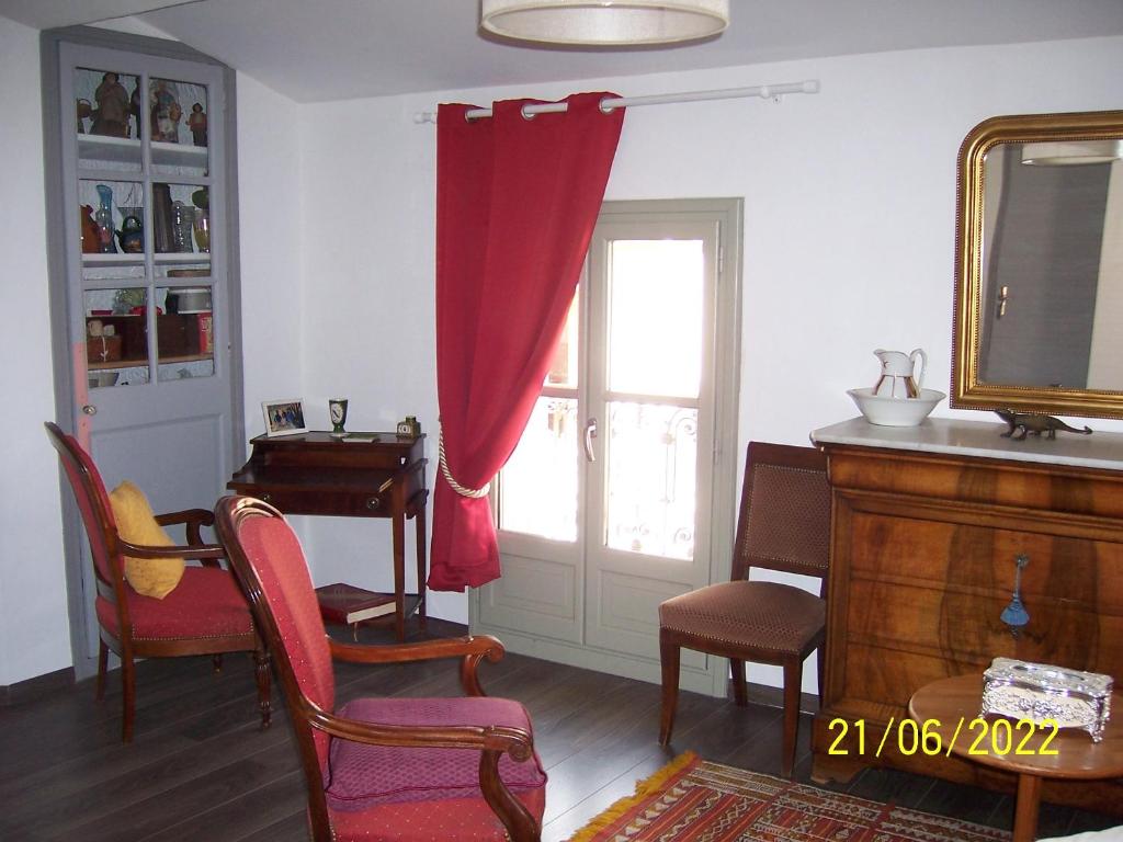 a living room with a red curtain and a window at Grande chambre, vue sur toits, cyclistes bienvenus in Béziers