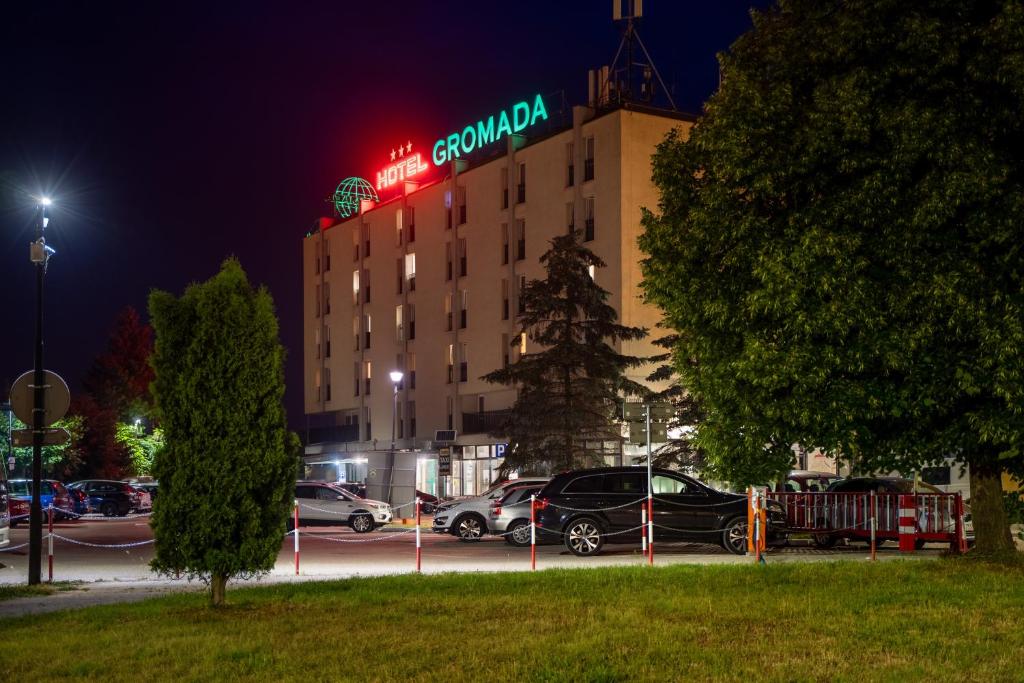 a hotel with cars parked in a parking lot at night at Hotel Gromada Łomża in Łomża