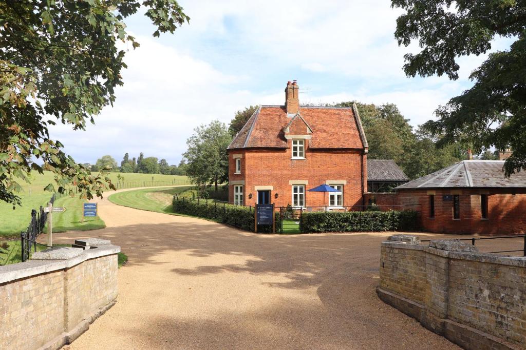 uma grande casa de tijolos vermelhos com uma entrada em Bridge House at Woodhall Estate em Hertford