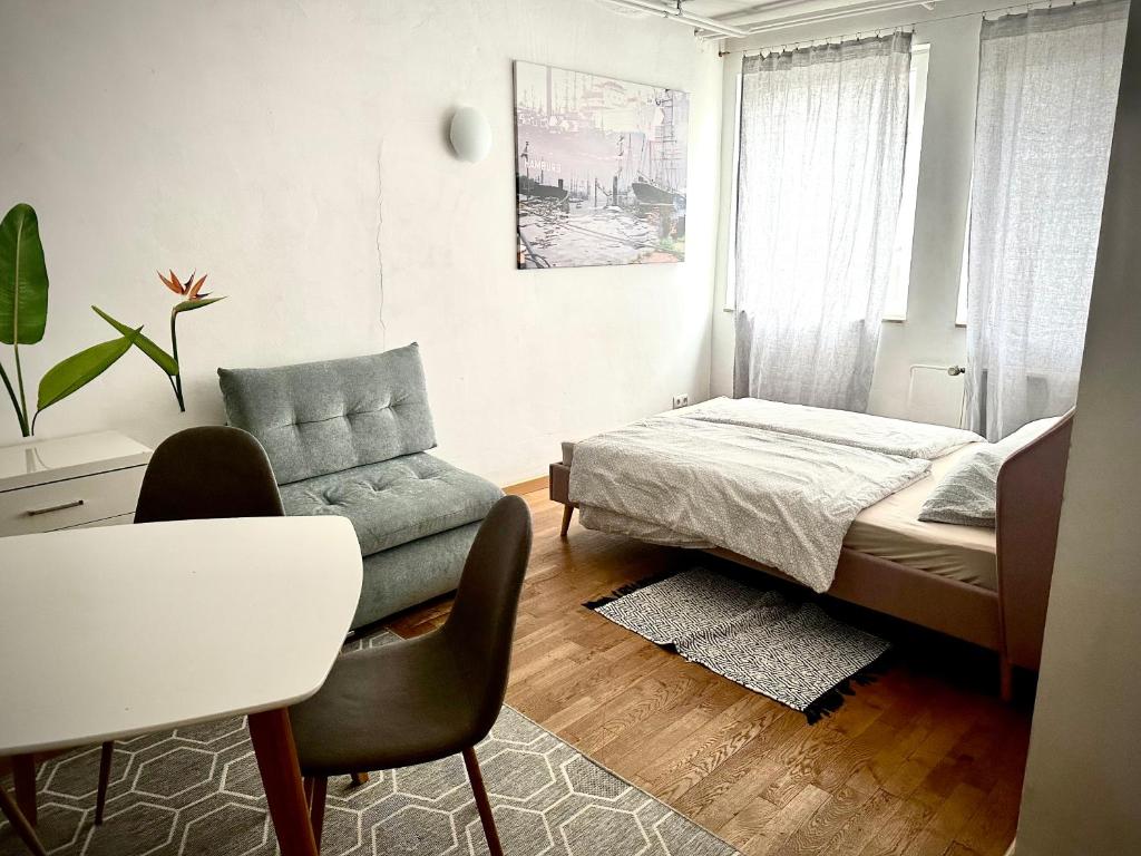a bedroom with a bed and a couch and a table at stayinhostel in Hamburg