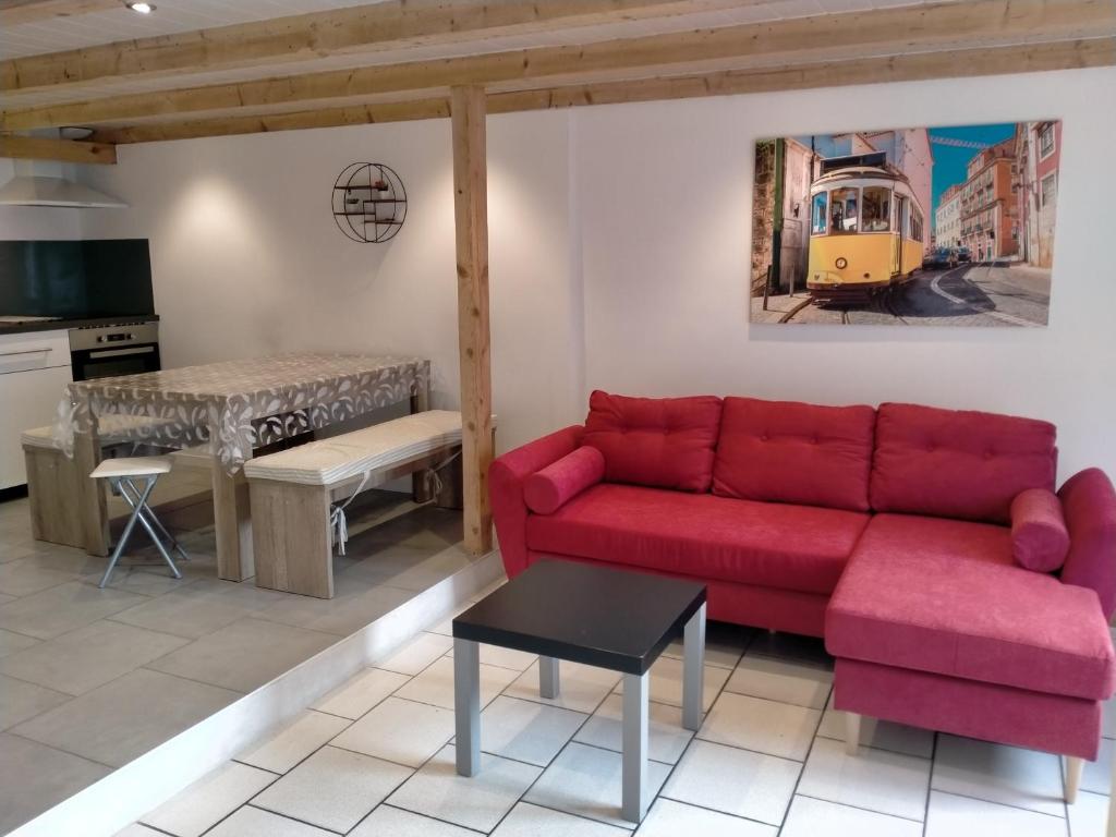uma sala de estar com um sofá vermelho e uma mesa em La Casa de Pimpele em Saint-Martin