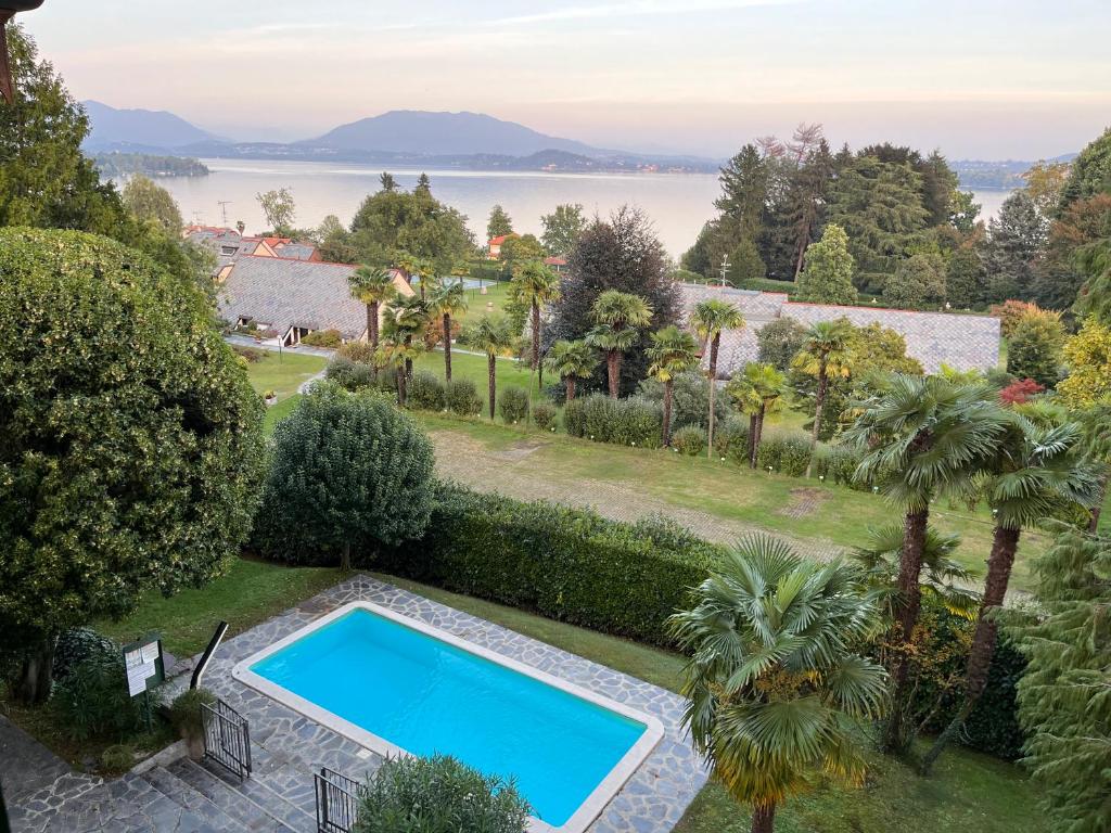 einen Pool in einem Garten mit Blick auf das Wasser in der Unterkunft VSC Apartment - Appartamento in villa storica vista lago e piscina in Lesa