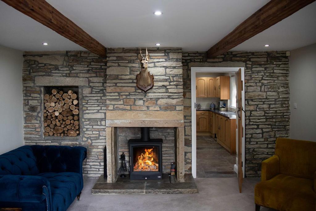 sala de estar con pared de piedra y chimenea en Croft House Cottage, en Halifax