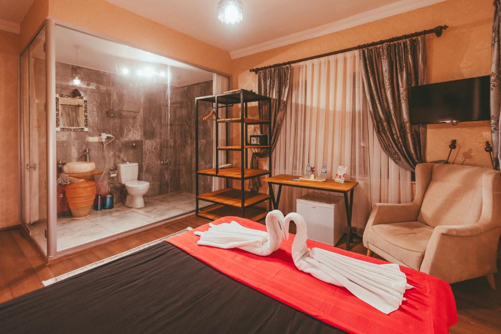 a hotel room with a bathroom with a bed with towels at Pigeon Valley Hotel in Uchisar
