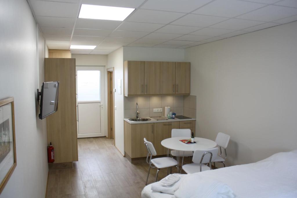 um quarto com uma cama, uma mesa e cadeiras em AK Apartments em Akureyri
