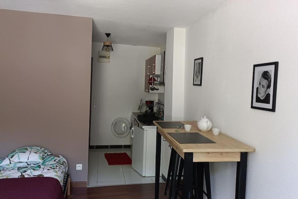 eine kleine Küche mit einem Tisch in einem Zimmer in der Unterkunft studio en face des salines in Salins-les-Bains