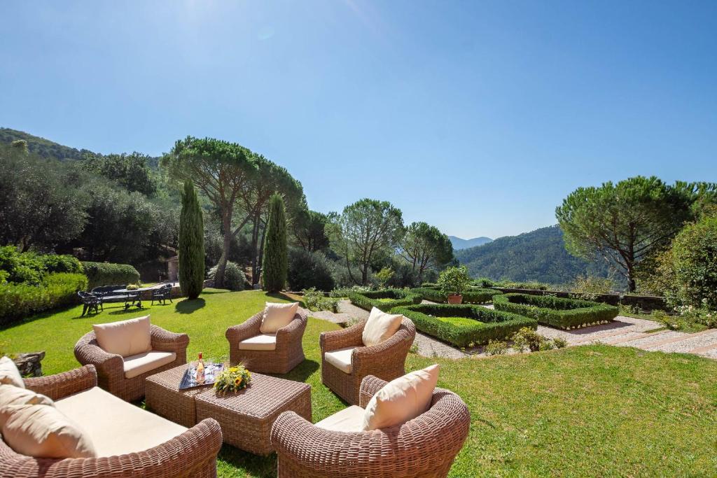 un jardín con sillas y mesas en el césped en Villa Igea 8, en Mastiano