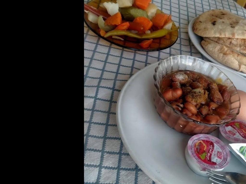 een tafel met borden en een kom eten bij Hotel minia in Al Minya