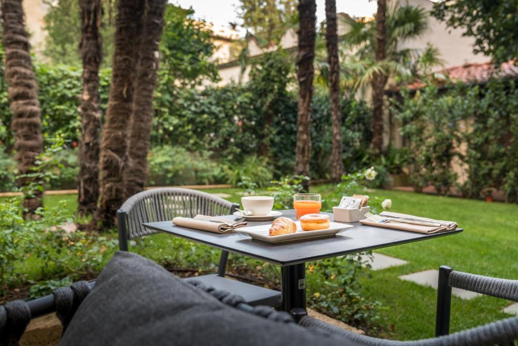 una mesa con un plato de comida y bebidas. en Hotel Ariele en Florence