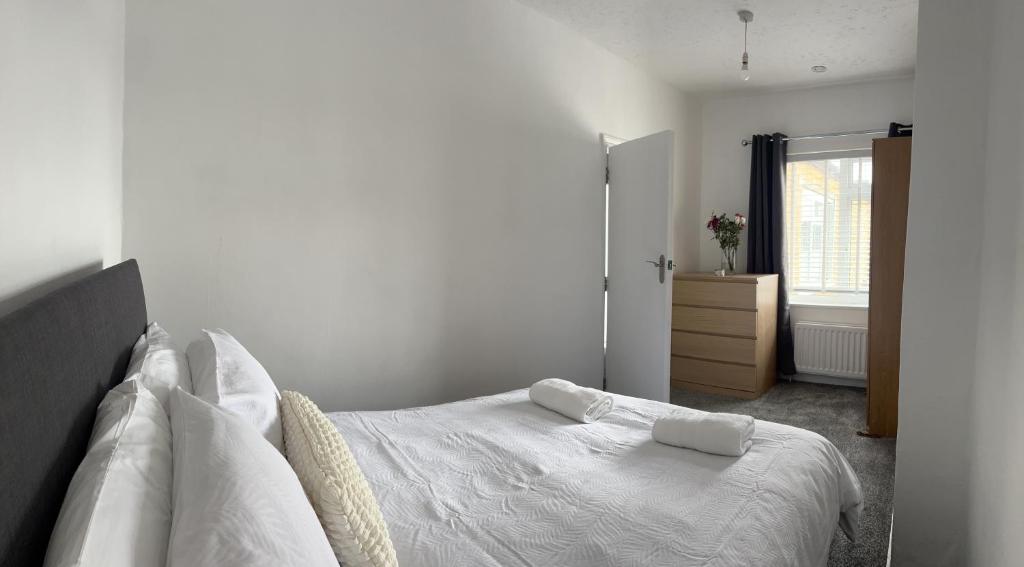 a bedroom with a white bed with two towels on it at Crown Road Apartment in Kent